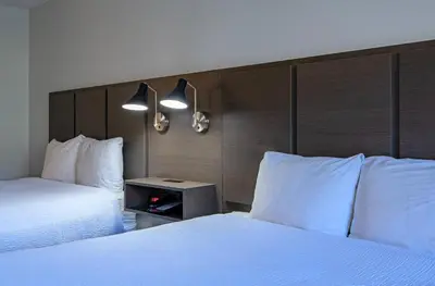 a hotel room with two beds with white pillows at Riverland Inn & Suites in Kamloops