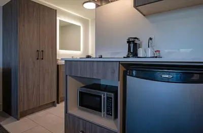 a kitchen with a stove and a microwave at Riverland Inn & Suites in Kamloops