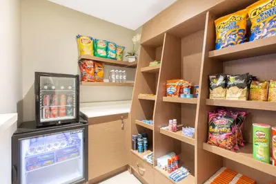 a room with a refrigerator and shelves with snacks at Microtel Inn & Suites by Wyndham Fort McMurray in Fort McMurray