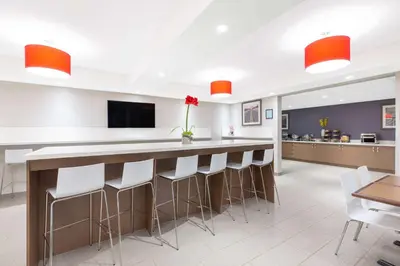 a large kitchen with a bar with stools at Microtel Inn & Suites by Wyndham Fort McMurray in Fort McMurray