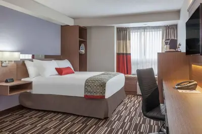 a hotel room with a large bed and a desk at Microtel Inn & Suites by Wyndham Fort McMurray in Fort McMurray