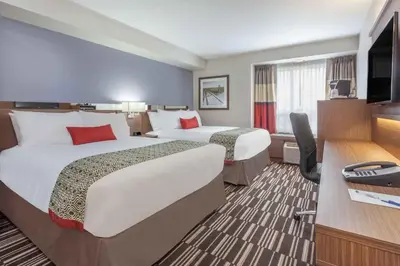 a hotel room with two beds and a television at Microtel Inn & Suites by Wyndham Fort McMurray in Fort McMurray