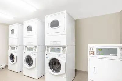three washing machines and a washer and dryer in a room at Microtel Inn & Suites by Wyndham Fort McMurray in Fort McMurray
