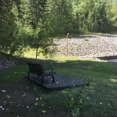 a bench sitting in the grass in a park at Fernie Fox Hotel in Fernie