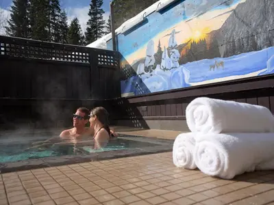 a man and woman in a jacuzzi in a hot tub at Fernie Fox Hotel in Fernie