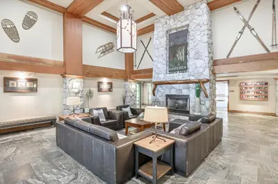 a large living room with a stone fireplace at The Best Top Floor Ski-in/Ski-out at the Aspens in Whistler