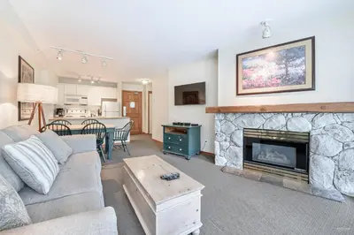 a living room with a couch and a fireplace at The Best Top Floor Ski-in/Ski-out at the Aspens in Whistler