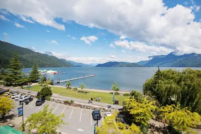 a view of a lake with mountains in the background at Harrison Beach Hotel in Harrison Hot Springs
