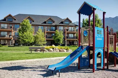 a playground with a slide in front of a building at Bighorn Meadows Resort in Radium Hot Springs