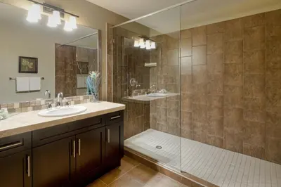 a bathroom with two sinks and a glass shower at Bighorn Meadows Resort in Radium Hot Springs