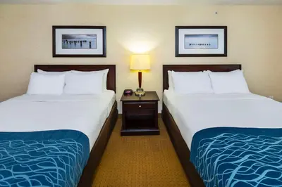 a hotel room with two beds and a table with a lamp at Comfort Inn & Suites in Edson