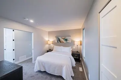 a bedroom with a white bed and two lamps at Sunrise Ridge Waterfront Resort in Parksville