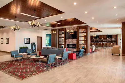 a lobby of a hotel with chairs and tables at Four Points by Sheraton Grande Prairie in Grande Prairie
