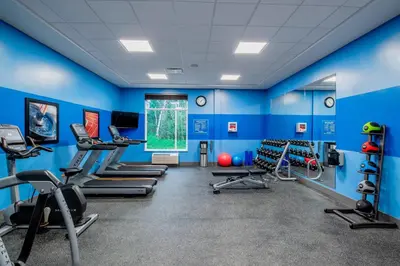 a gym with blue walls and treadmills at Four Points by Sheraton Grande Prairie in Grande Prairie