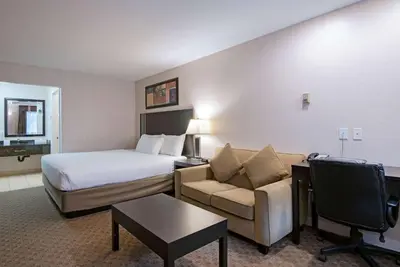 a hotel room with a bed and a couch at Travelodge by Wyndham Kamloops Mountview in Kamloops