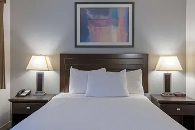 a hotel room with a bed with two lamps on tables at Travelodge by Wyndham Kamloops Mountview in Kamloops