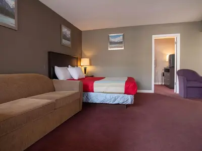 a hotel room with a bed and a couch at Best Budget Inn & Suites Kamloops in Kamloops