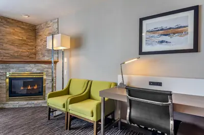 a room with a desk and chairs and a fireplace at Quality Inn in Kamloops