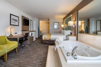 a hotel room with a bed and a bath tub at Quality Inn in Kamloops