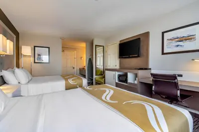 a hotel room with two beds and a flat screen tv at Quality Inn in Kamloops