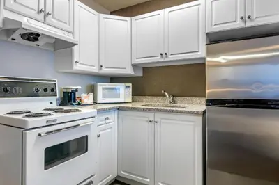 a white kitchen with white cabinets and appliances at Quality Inn in Kamloops