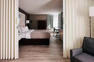 a bedroom with a bed and a chair and a couch at Quality Inn in Kamloops