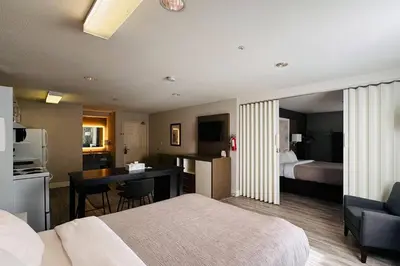 a hotel room with a bed and a desk and a kitchen at Quality Inn in Kamloops