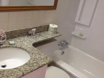 a bathroom with a sink and a toilet and a bath tub at Travelodge by Wyndham Edmonton East in Edmonton