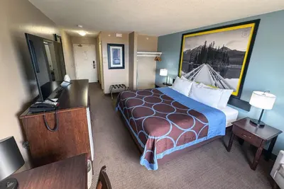 a hotel room with a large bed and a desk at Super 8 by Wyndham Edmonton South in Edmonton