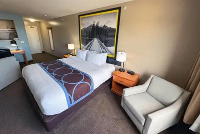 a hotel room with a bed and a chair at Super 8 by Wyndham Edmonton South in Edmonton