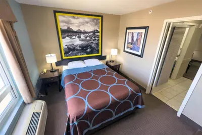 a hotel room with a bed and a painting on the wall at Super 8 by Wyndham Edmonton South in Edmonton