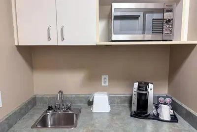 a kitchen counter with a sink and a microwave at Super 8 by Wyndham Edmonton South in Edmonton