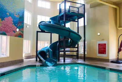 a swimming pool with a slide in a building at Super 8 by Wyndham Edmonton South in Edmonton