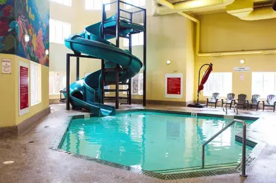 a indoor swimming pool with a slide in a building at Super 8 by Wyndham Edmonton South in Edmonton