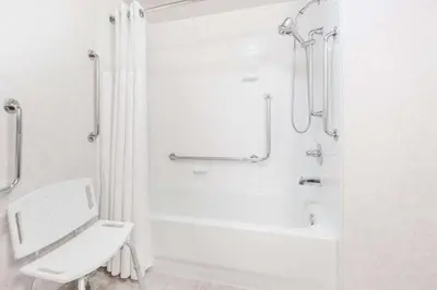 a bathroom with a shower and a toilet and a sink at Ramada by Wyndham Sherwood Park in Sherwood Park