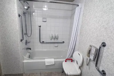 a bathroom with a bath tub and a toilet at Ramada by Wyndham Sherwood Park in Sherwood Park