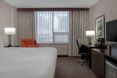 a hotel room with a bed and a desk and a computer at Ramada Plaza by Wyndham Calgary Downtown in Calgary