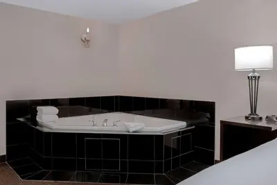 a bathroom with a bath tub with a sink at Ramada Plaza by Wyndham Calgary Downtown in Calgary