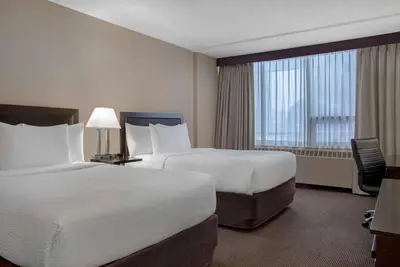 a hotel room with two beds and a window at Ramada Plaza by Wyndham Calgary Downtown in Calgary
