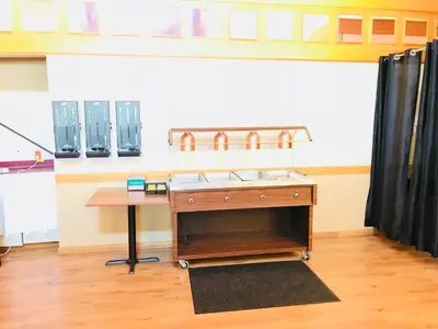 a kitchen with a stove and a table in a room at Northern Star Hotel & Convention Center in Slave Lake