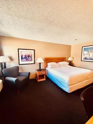 a hotel room with a bed and a chair at Royal Hotel Lloydminster in Lloydminster