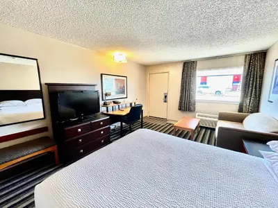 a hotel room with a bed and a flat screen tv at Royal Hotel Lloydminster in Lloydminster
