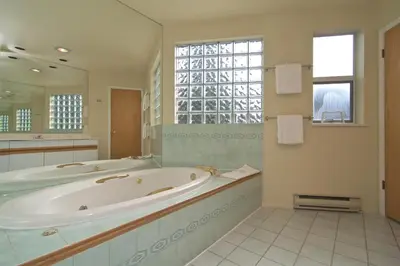 a large bathroom with a tub and a large mirror at Snowbird by Bill in Whistler