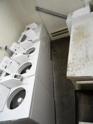 two washing machines in a utility room with a counter at English Bay Hotel in Vancouver