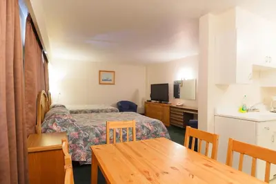 a small hotel room with a bed and a table at English Bay Hotel in Vancouver