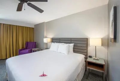 a hotel room with a bed and a purple chair at Coast Prince George Hotel by APA in Prince George