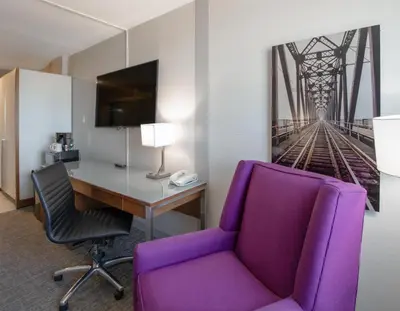 an office with a purple chair and a desk at Coast Prince George Hotel by APA in Prince George