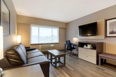 a living room with a couch and a tv at Best Western Premier Aberdeen Kamloops in Kamloops