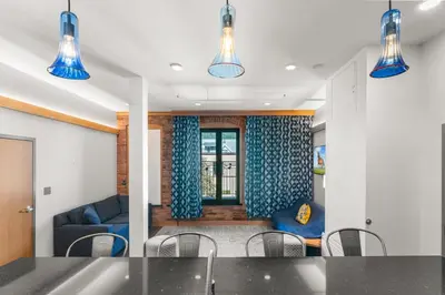 a living room with blue curtains and a table and chairs at Savoy Hotel in Nelson