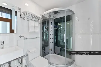 a bathroom with a shower and a toilet and a sink at Savoy Hotel in Nelson